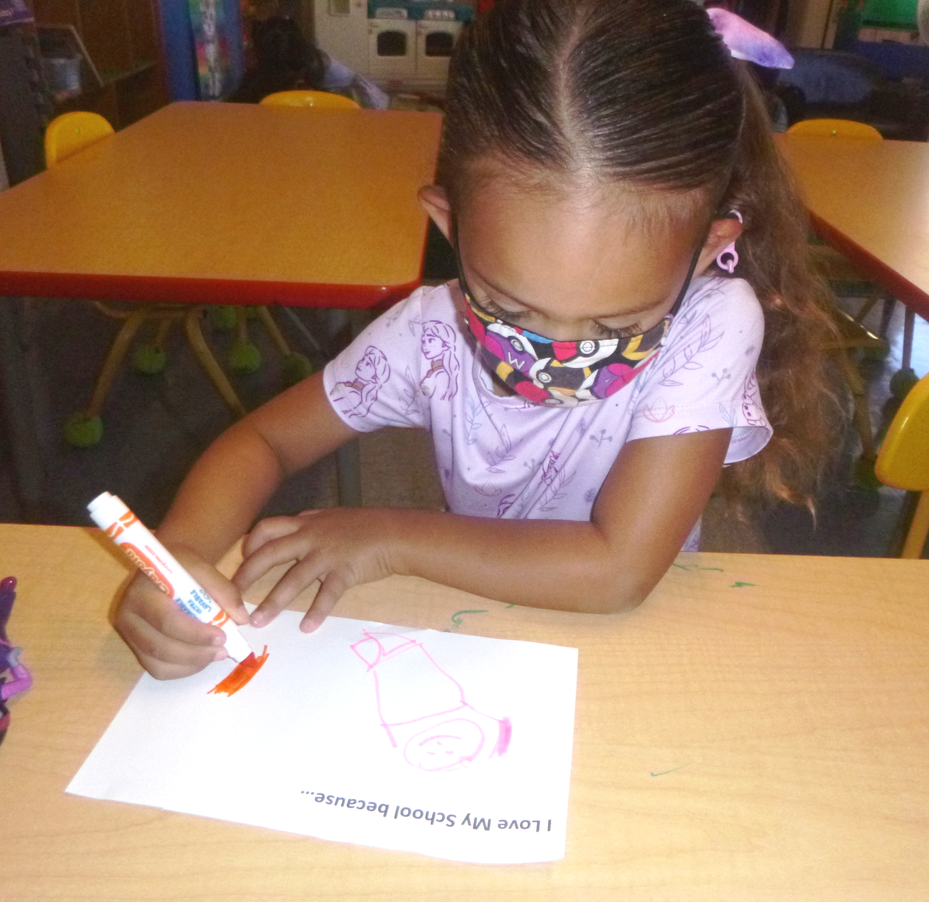 Butterfly Student drawing her response to "I love my school because..."