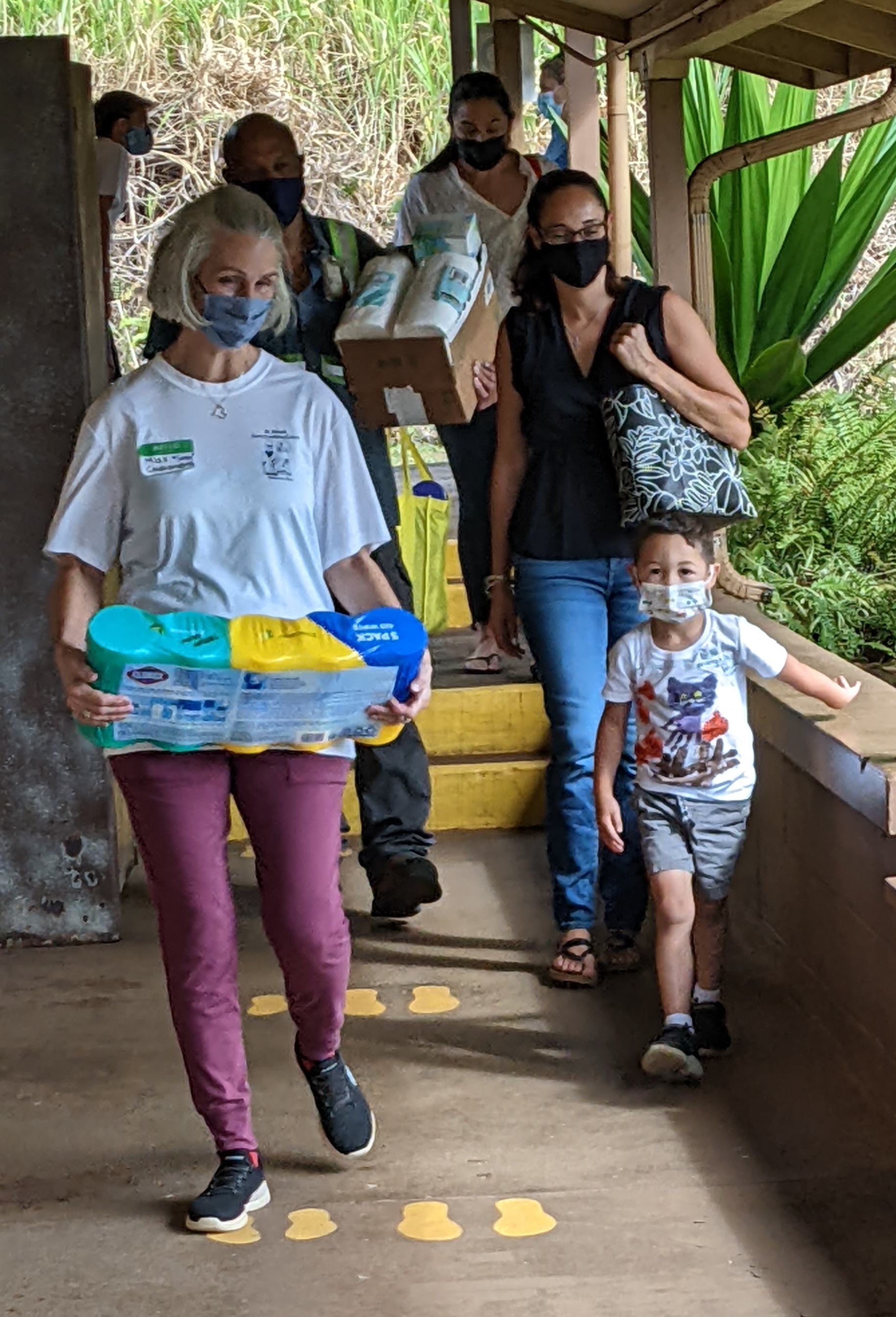 Miss Comer, student, and family carrying in supplies